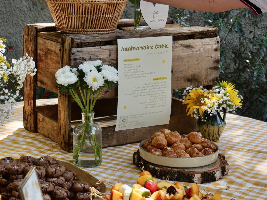 Buffet sucré dressé sur une caisse en bois, choux et brochettes de fruits