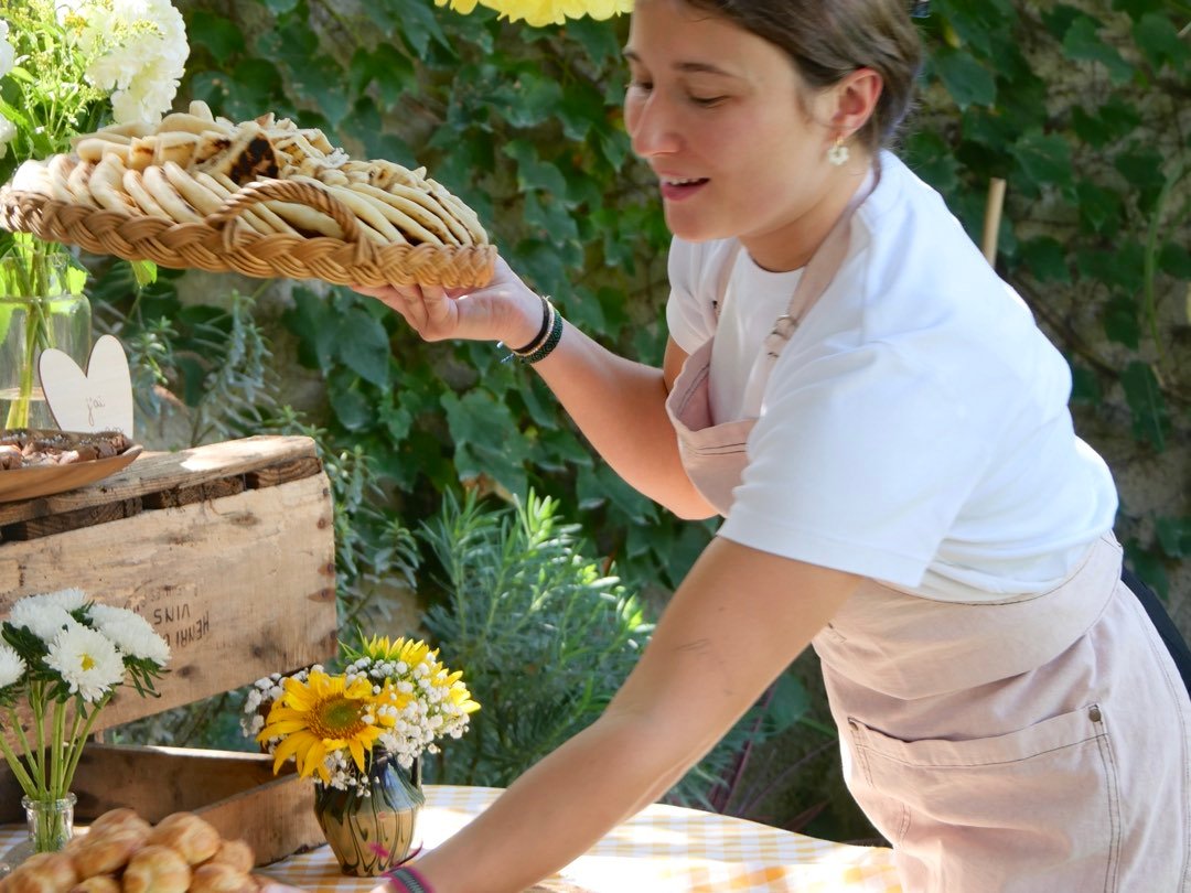 La cheffe dressant une corbeille de pains sur un buffet