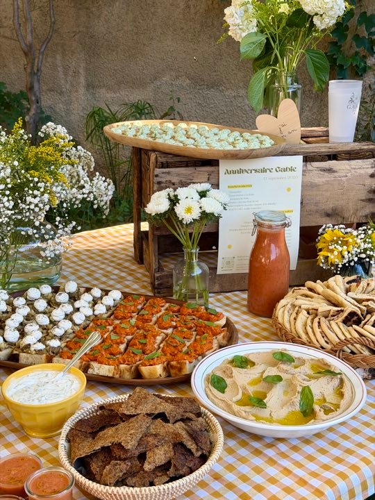 Buffet salé dressé en extérieur : houmous, bruschettas et pains